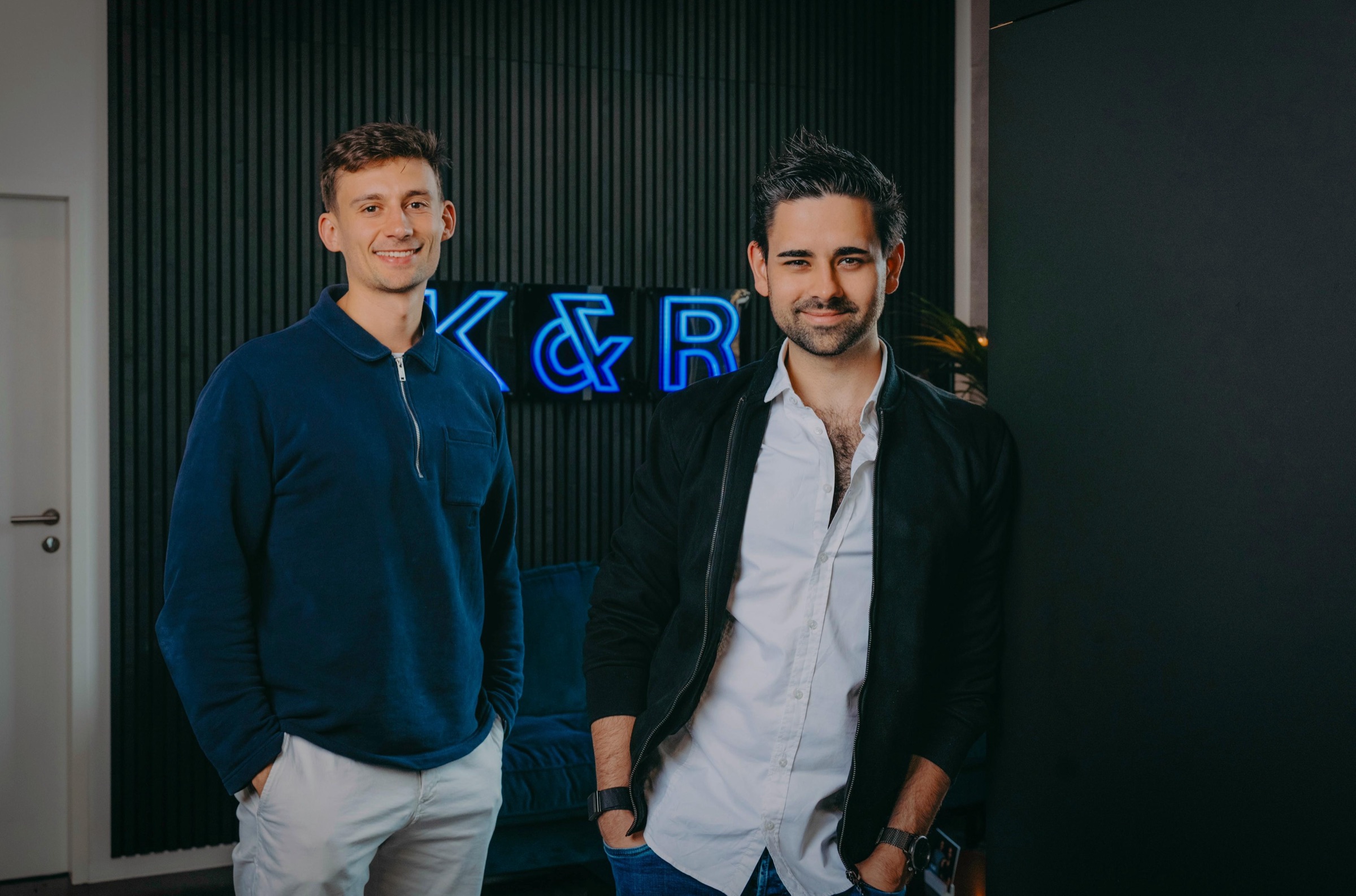 Nicolas Rose und David Klein vor dem K&R-Neonschild